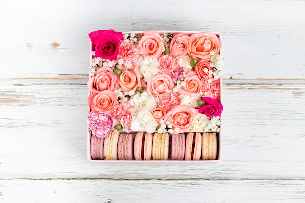 Floral arrangement of pink roses with macarons of different colors