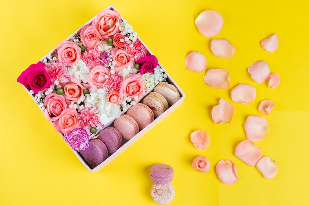 Floral arrangement of pink roses with macarons of different colors