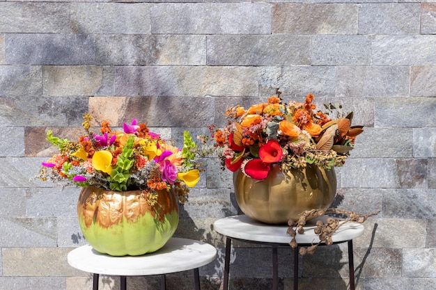 Floral arrangement of roses inside pumpkin decorated for a different Halloween