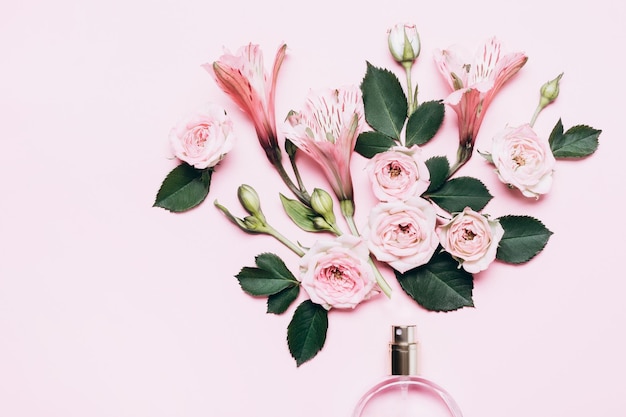 Floral arrangement with perfume bottle and pink flowers Minimal beauty concept