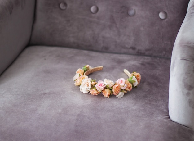 Floral headband laying on grey velour chair