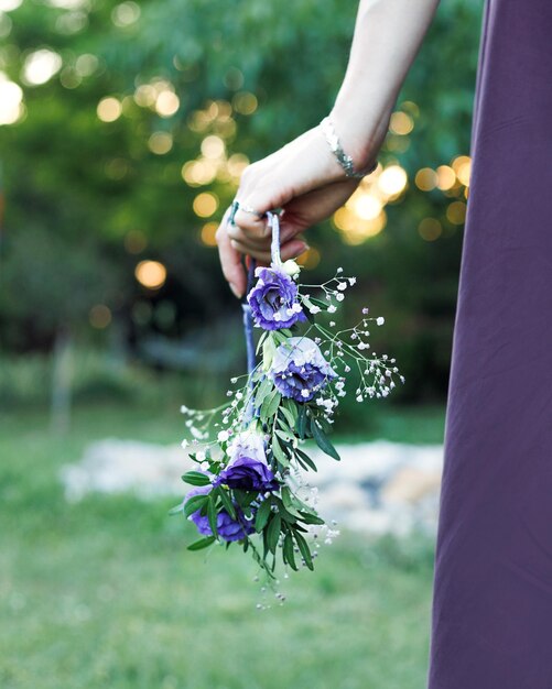 Floral wreath of white and lilac eustoma in the hand of a beautiful woman