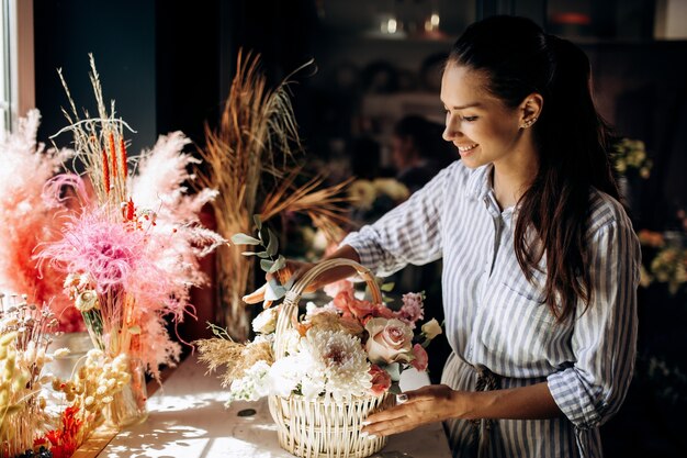 Florist collections a bouquet in the basket from fresh flowers of pastel colors in the flower shop .