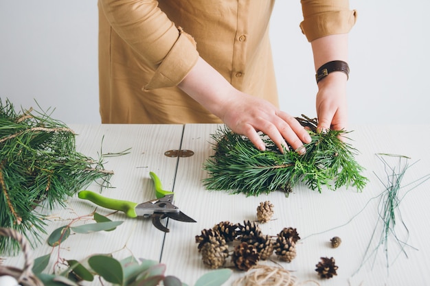 Florist decorator making Christmas wreath 