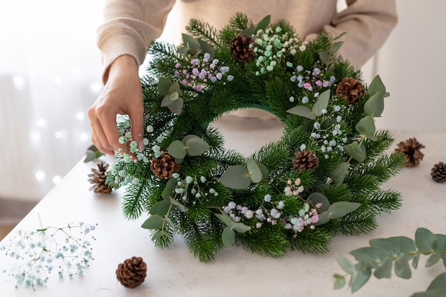 Florist hands holding Christmas wreath Christmas wreath workshop