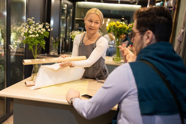 Florist and his client in a flower shop discussing a bouquet