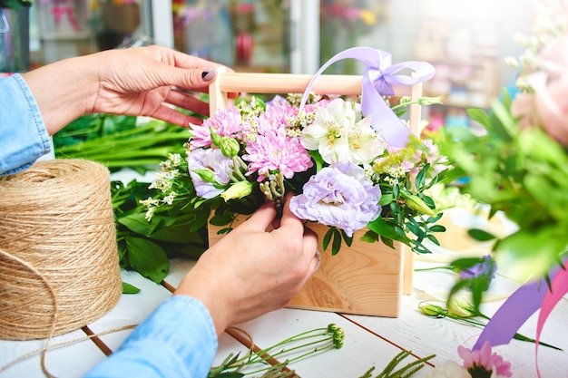 The florist makes the bouquet top view on background white Board