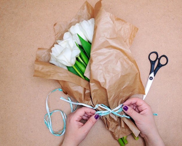 Florist makes a bouquet of white tulips