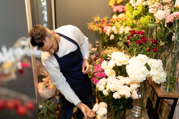 the florist in the refrigerator chooses fresh flowers for a bouquet.