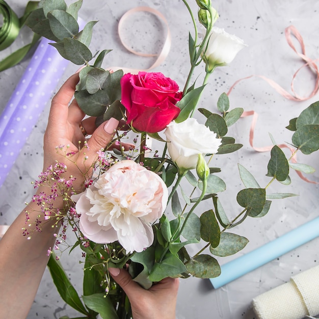 Florist tools and workplace with ribbons, flowers and scissors