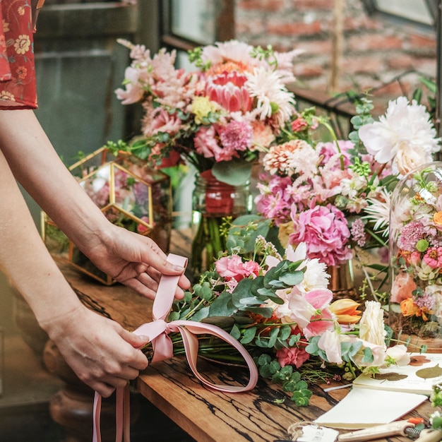 Florist tying a ribbon on a bouquet