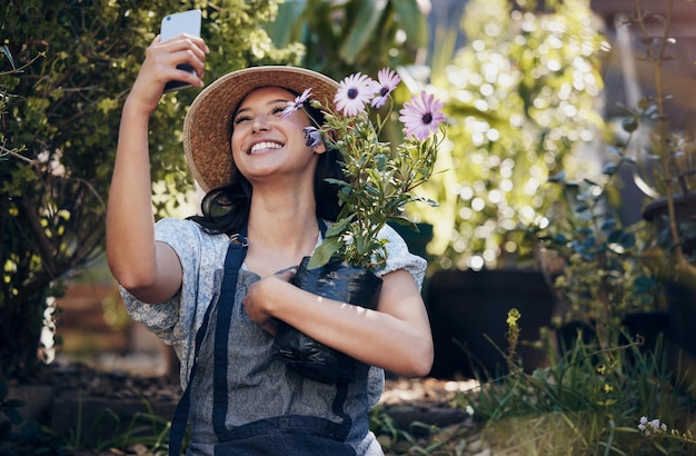 Florist woman garden and selfie in nursery smile and hug plant with excited face for sustainable small business Girl entrepreneur and love for plants growth and nature with post for social media