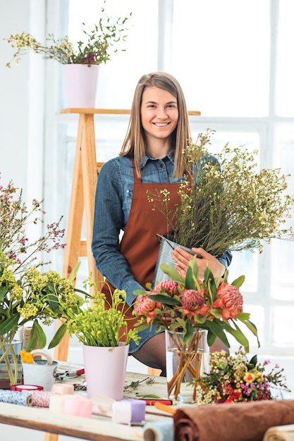 Florist at work: the young girl making fashion modern bouquet of different flowers