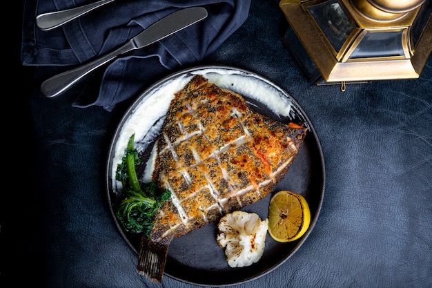 Flounder fillet roasted in a skillet with herbs and lemon