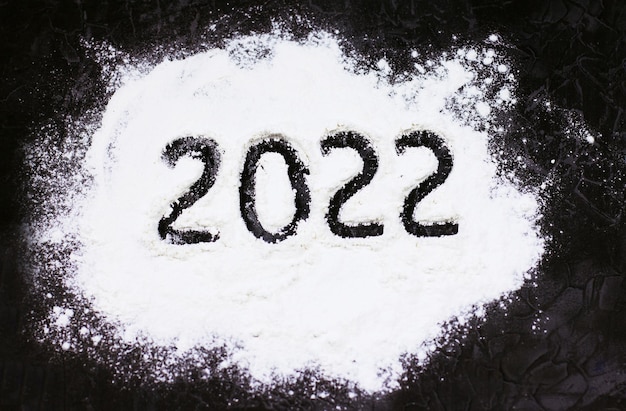 Flour on a dark background and numbers 2021 New year Christmas cooking baking cooking