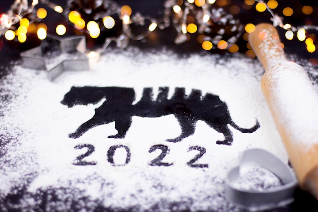 Flour on a dark background and silhouette of a tiger, new year 2022, silhouette and symbol of the new year, Chinese new year New Year Christmas cooking baking