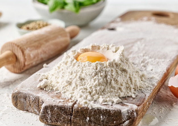 Flour and egg yolk on white kitchen table