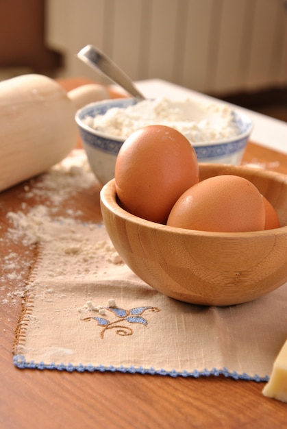 Flour, eggs and milk on a wooden table