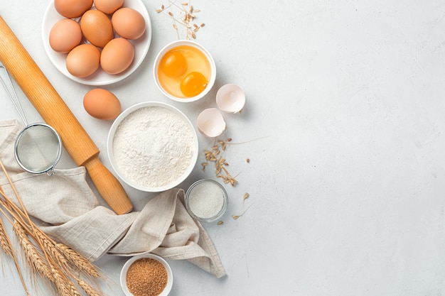 Flour eggs sugar rolling pin on a gray background ingredients for baking