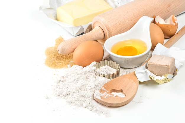 Flour eggs yeast sugar butter Wooden kitchen utensils Food background