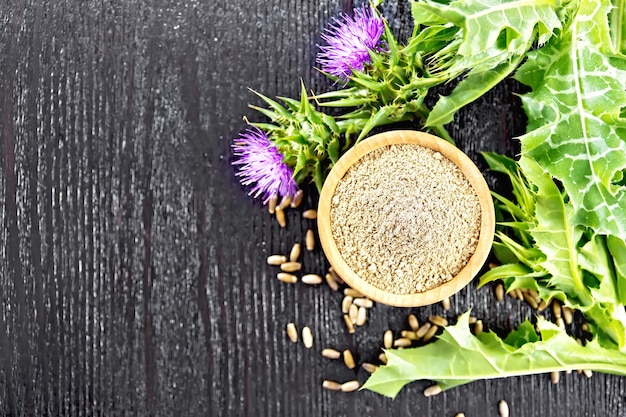 Flour milk thistle in bowl on board top