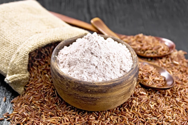 Flour red rice in bowl on dark board