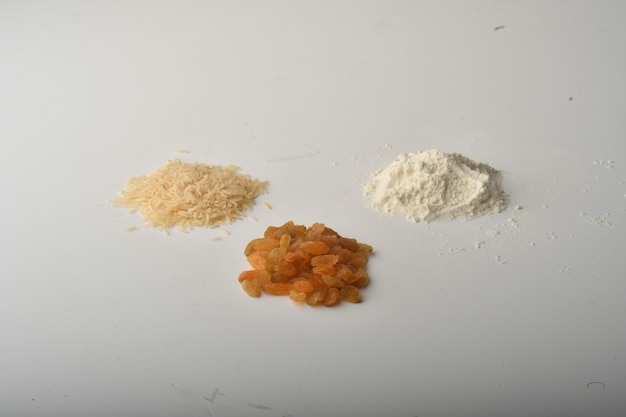 Flour, wheat, rice, raisins and coins on a white background