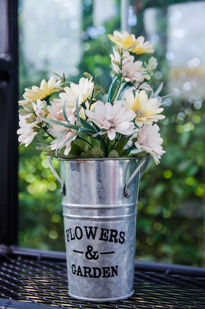 Flower in aluminium pot on black steel shelves