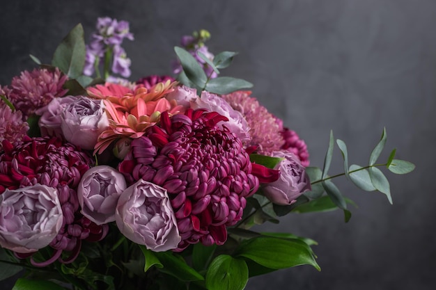 Flower arrangement of chrysanthemums and roses on dark background