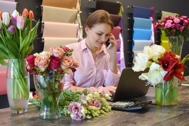 flower business. Floral retail store. Woman florist taking an order. Flowers delivery