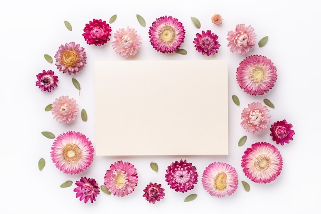 Flower composition. Blank of paper and frame made of dry flowers on white background. Flat lay. Top view. Copy space - Image