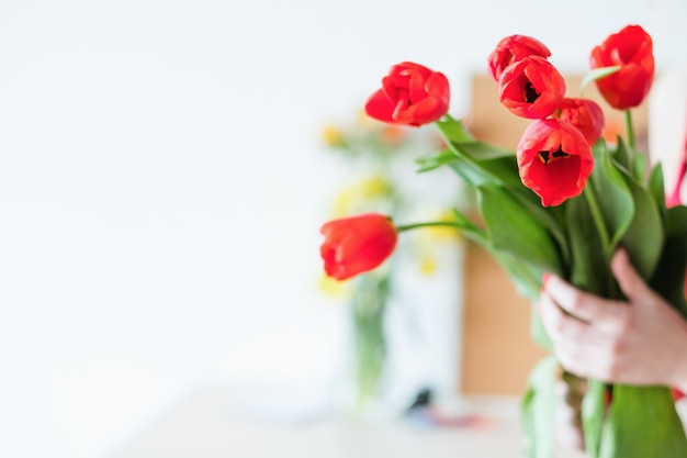 Flower delivery. florist holding a red tulip bouquet. spring festive bunch