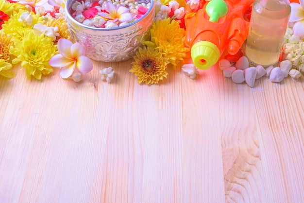 flower and pipe gun on wood background for Songkran Festival or Thai New Year