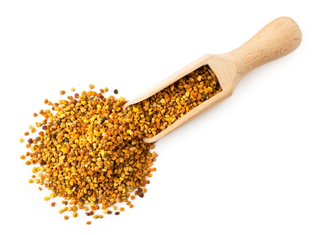 Flower pollen in wooden scoop on white