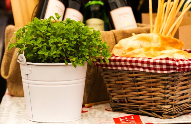 Flower pot with a basket of pastries in a street cafe