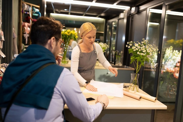 A flower shop customer is waiting for a bouquet to be bought for him