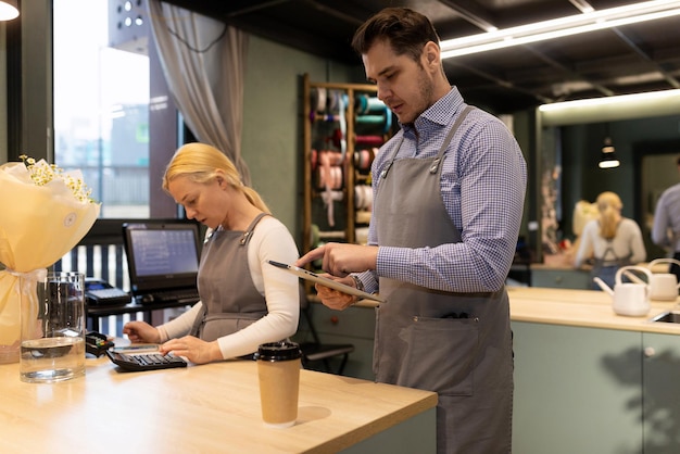 Flower shop employees count profits and expenses on a calculator and enter them into the accounting