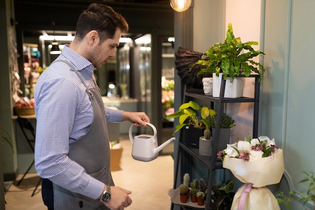 Flower shop manager watering potted plants