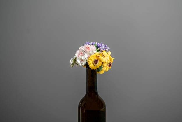 A flowers bouquet in the champagne bottle as the symbol of holidays