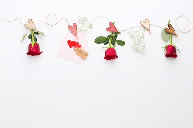 Flowers composition. Frame made of red rose on white background. Flat lay, top view, copy space.