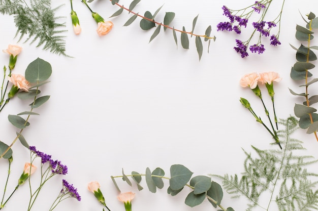 Flowers composition. Paper blank, carnation flowers, eucalyptus branches on pastel