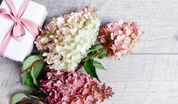 Flowers composition workspace with rose flowers gift paper bag top view flat lay