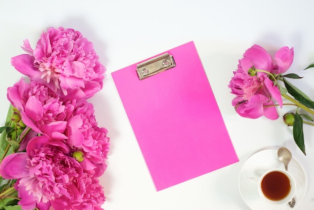 Flowers peonies and tablet for writing on a white background Horizontal view