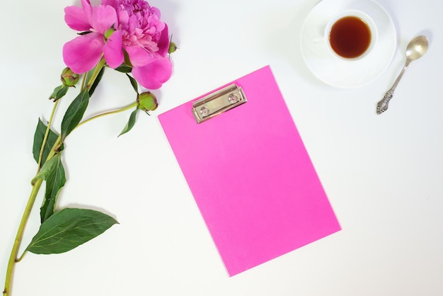 Flowers peonies and tablet for writing on a white background Horizontal view