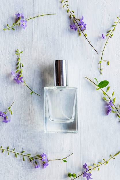 Flowers and perfume bottle on a white wooden table