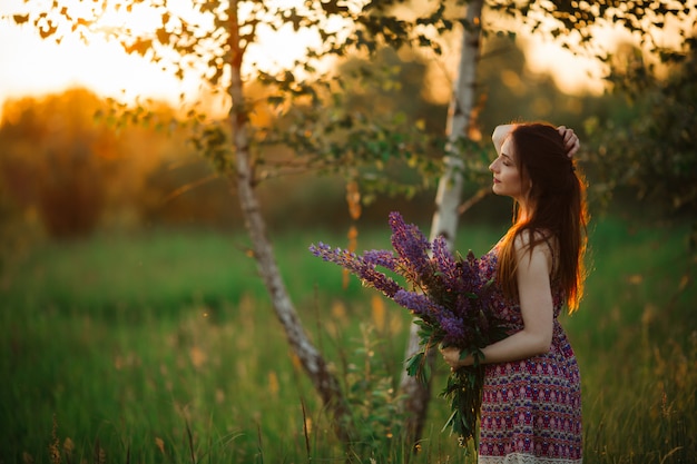 Flowers and the woman palm in the field. Lit evening sun