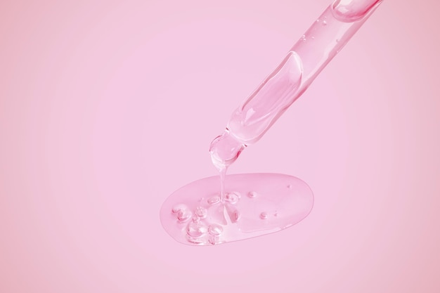 A flowing clear gel from a pipette A lot of flowing gel in a big drop With bubbles On a pink background