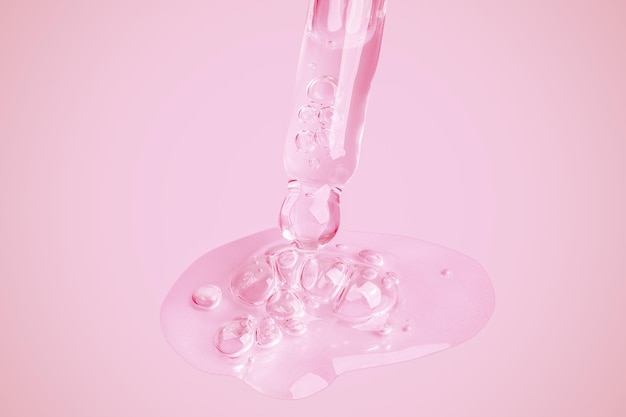 A flowing clear gel from a pipette A lot of flowing gel in a big drop With bubbles On a pink background