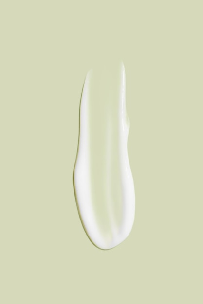 The flowing cream on a green background Smudged flowing smear of cosmetic cream