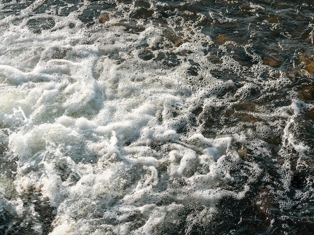 Flowing dark water texture White water foam small whirlpool water background